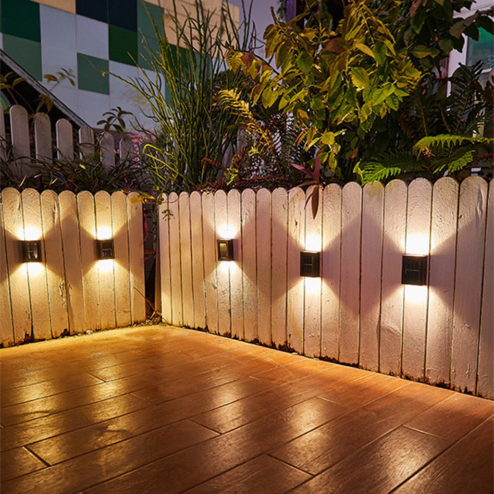 SolarFlare wall light mounted on a house wall with the light on, solar garden lamp