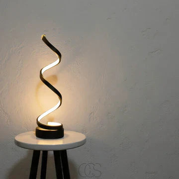 Spiral table lamp placed on a bedside table with atmospheric lighting modern bedside lamp