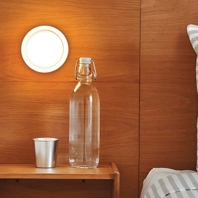 Dimple Aura glass wall light switched on, warm light living room lamp