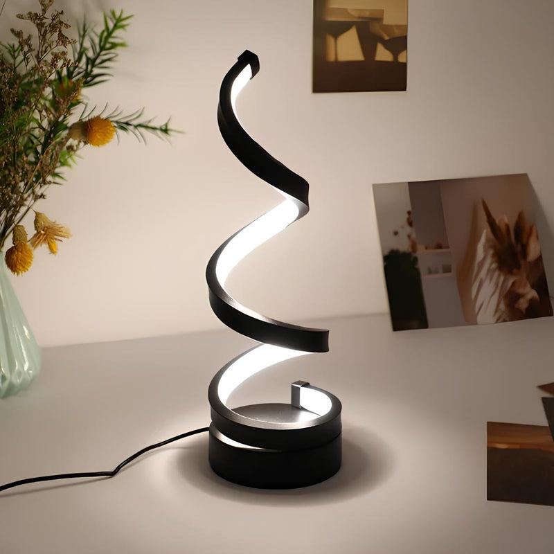 Spiral table lamp switched on with warm glow against a dark background decorative table lamp